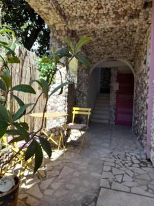 een patio met 2 stoelen en een stenen muur bij Vila Verica M in Kravlja