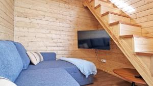 Una sala de estar con un sofá azul y un televisor. en PANORAMA Władysławowo, en Władysławowo