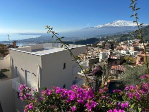 a view of a city with pink flowers at Casa DiMa - La Pigna Verde in Taormina