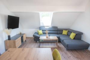 a living room with a blue couch and yellow pillows at Vila Jelena - modern spacious apartments near Vintgar Gorge & Bled in Zgornje Gorje