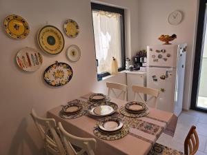 a kitchen with a table with plates on the wall at Casa DiMa - La Pigna Verde in Taormina
