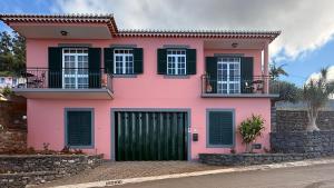a pink house with black windows and a green door at Vila Rocha Do Sol 59A - Ensuite Room With Balcony View in Canhas