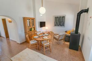 a living room with a table and a wood stove at Casa Esmeralda - Vineyard View in Porches