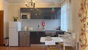 a kitchen with a table and a white refrigerator at Vila Rocha Do Sol 59A - Ensuite Room With Balcony View in Canhas