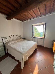 a bedroom with a bed and a window at Appartamento Bellavista in Radda in Chianti