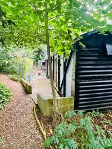 een boom naast een gebouw met een trap bij The Railway Carriage - Blue in Glasbury +4 foto's