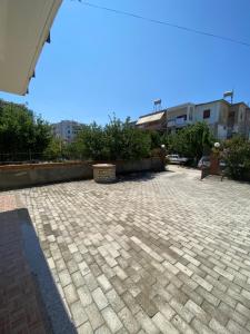 a brick patio with a fence and some buildings at Kapo Residence in Vlorë +2 photos