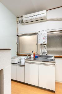 una cucina con mobili bianchi e un lavandino di Higashi-Ueno 3 a Tokyo Altre 28 foto