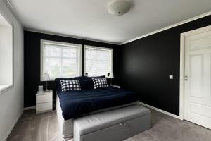 una camera con un letto blu e due finestre di Nordic Villa Retreat ad Ålesund