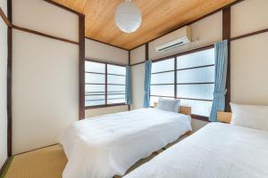 due letti in una stanza con due finestre di Higashi-Ueno 3 a Tokyo