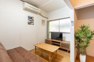 un soggiorno con un divano e una TV di Higashi-Ueno 3 a Tokyo