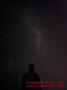 a person is looking up at the night sky at Tekapo Aunt Susan Holiday House in Lake Tekapo