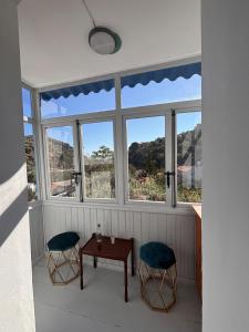 a room with two chairs and a table and windows at Olive Stonehouse in Plomarion
