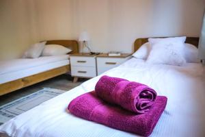 a purple towel sitting on top of a bed at Agroturystyka BieszCzadowa Dolina Cisna in Cisna