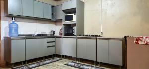 a kitchen with white cabinets and a microwave at Sítio, Família e Amigos! 1km do centro in Rio Rufino