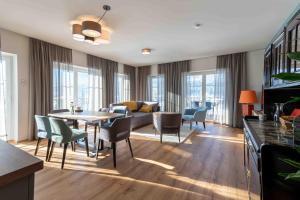 a living room with a couch and a table and chairs at SINGULAR - Mountainview Apartments in Bad Goisern