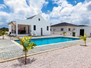 a villa with a swimming pool in front of a house at Villa Carolina at Ayo Bonaire in Kralendijk