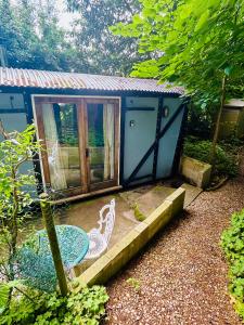 een blauwe hut met een tafel en een terras bij The Railway Carriage - Blue in Glasbury