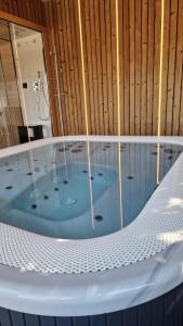 a jacuzzi tub in a room with at Le Chalet de la Répandise - Gîte Vosges 9 pers, Spa privé & Piscine - Proche Gérardmer in Laveline-du-Houx