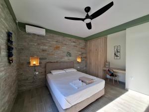 a bedroom with a bed and a ceiling fan at Bellevia Stone Pool Villa in Kouvéllai +28 photos