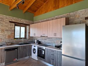 a kitchen with wooden cabinets and a white refrigerator at Bellevia Stone Pool Villa in Kouvéllai