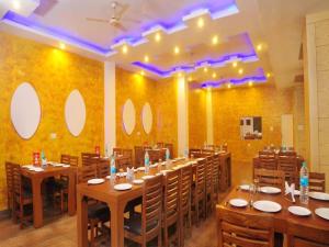 ニューデリーにあるHotel City Height - 2 Min from New Delhi Railway Stationのダイニングルーム(テーブル、椅子付)、壁(鏡付)