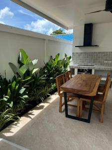 a wooden table and chairs on a patio with plants at Chalong Home Phuket in Phuket