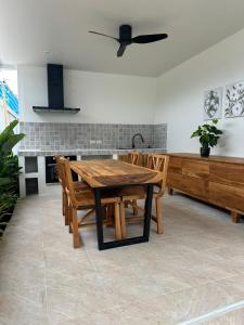 a kitchen with a wooden table and wooden chairs at Chalong Home Phuket in Phuket +5 photos