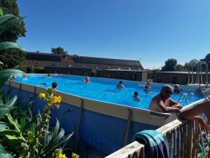 a group of people swimming in a swimming pool at Mobil home neuf à étaples à 5 minutes du touquet in Étaples