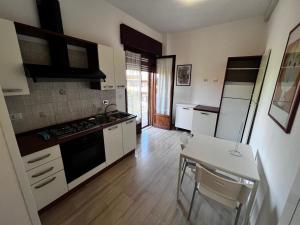 a kitchen with white cabinets and a table and a stove at Abbraccio Apart in Rome