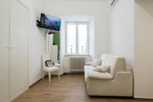 a white living room with a couch and a tv at Residenza IL COLLE in Subiaco +26 photos