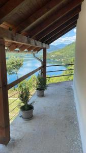 a porch with two potted plants and a view of a lake at Cottage Arinda in Jajce +20 photos