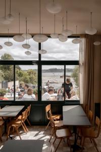 a restaurant with tables and chairs and a large window at Hôtel Restaurant Bellevue in Bréhat +67 photos