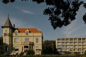 an old building with a turret next to a building at Vila Foz Hotel & SPA - member of Design Hotels in Porto