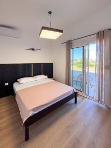 a bedroom with a large bed and a balcony at Harasani apartments in Ulcinj