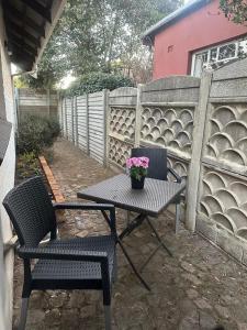 Una mesa de picnic y dos sillas con una planta en maceta encima. en Klaverton Daisy, en Benoni