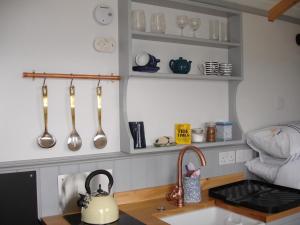 a kitchen with a sink and a counter with utensils at Apple Tree Shepherd's Huts - Blackberry Hut in Saint Endellion