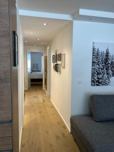 a hallway of a house with a couch and a bedroom at Spacious 3 Room Apartment - Family-Friendly - Central Leukerbad - Great Views in Leukerbad