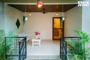 a room with a door and a table with plants at Belas Palmeiras by VEO - Part of StayVista with Pool & Bonfire in Alibaug