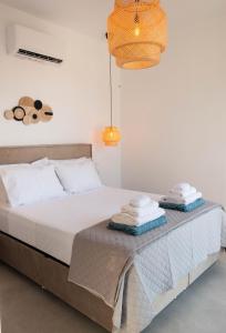 a bedroom with a bed with two towels on it at Mediterranean Blue Suites & Villa - Blue Bay Suite in Tympáki