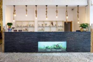 a lobby with a large tv in a brick wall at Sanya Yalong Bay Zhenghe Jingmei Hostel - Free Public Kitchen in Sanya