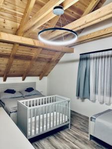 a bedroom with two twin beds and a ceiling with wood at Wellness chata pod Orechom in Dolná Lehota