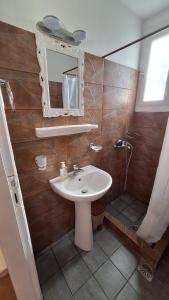 a bathroom with a sink and a shower and a mirror at Armonia Guesthouse in Panormos Skopelos