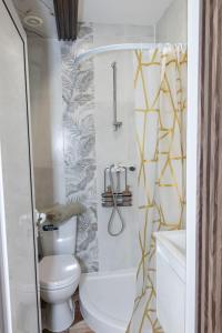 a small bathroom with a toilet and a shower at Good Mood Apartments & Parking in Plovdiv +37 photos