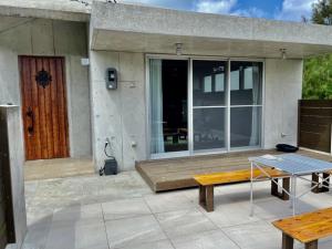 a patio with a wooden bench and a table at 恩納村リゾート貸別荘 COCO PLUS No2 in Onna