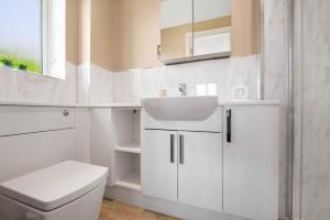 a white bathroom with a sink and a toilet at WhiskAwayHomes - Pirie Avenue in Hindlip +31 photos