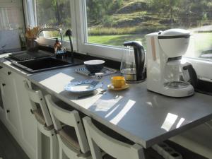a kitchen counter with a coffee maker and a window at Stuga med bastu i naturen nära Stockholm in Järna
