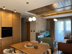 a living room with a dining table and a kitchen at Apartment MonteBreza Spa in Kolašin