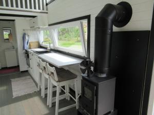 a kitchen in a tiny house with a stove at Stuga med bastu i naturen nära Stockholm in Järna +9 photos