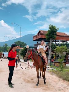 una donna a cavallo con una ragazza sopra di Mây's garden camping a Tây Ninh Altre 111 foto